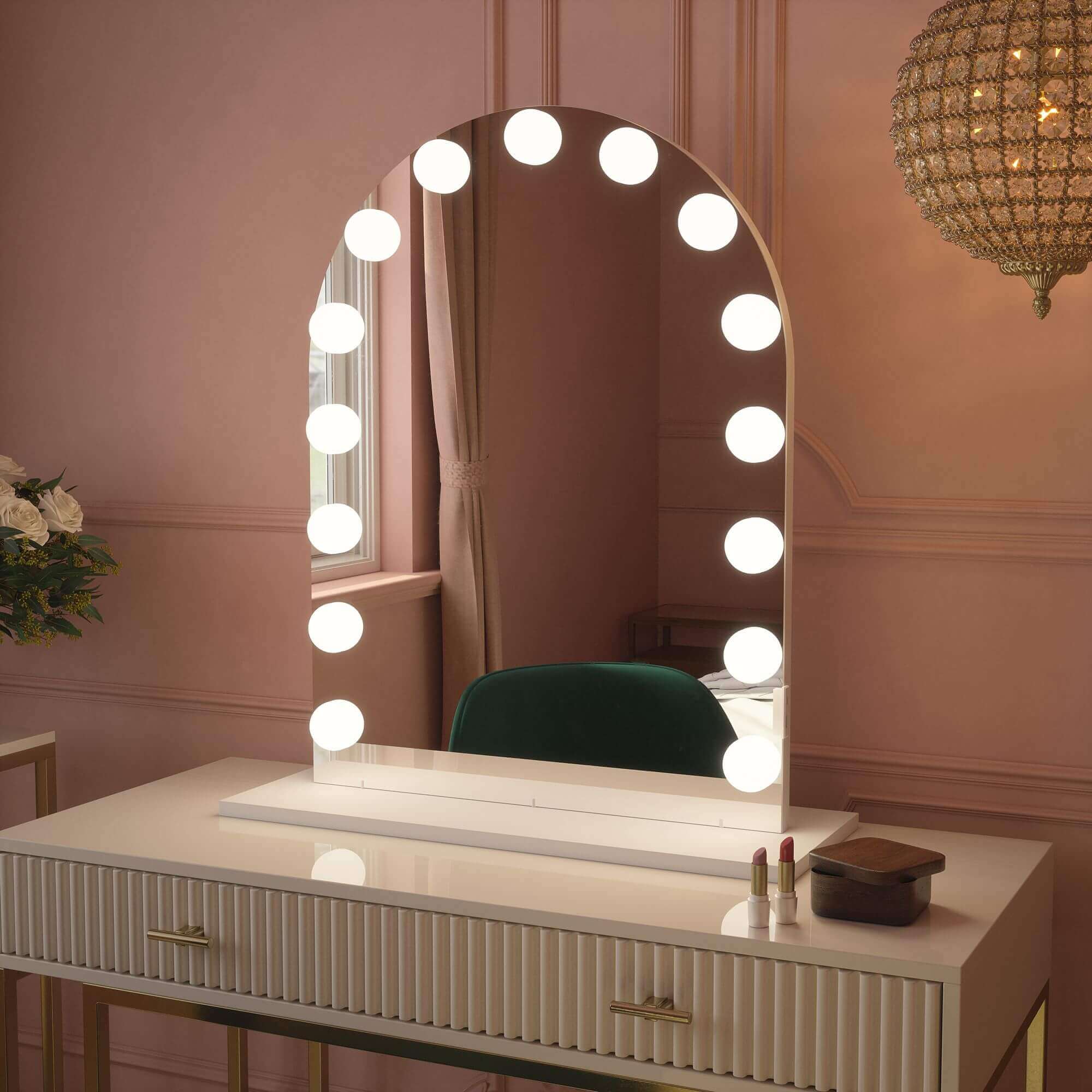 Charlize Arch Hollywood Mirror with LED bulbs on vanity table, showcasing warm lighting in elegant room. Modern beauty accent accessory.